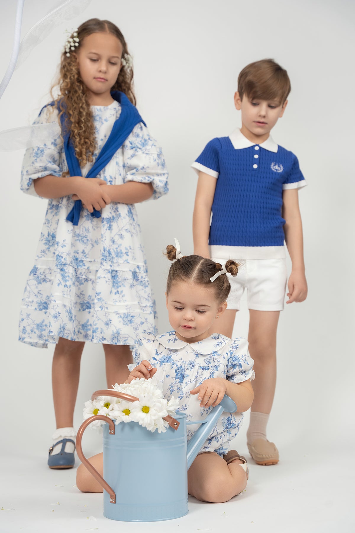 Kids floral dress set with blue knit polo vest and white shorts, blue accents