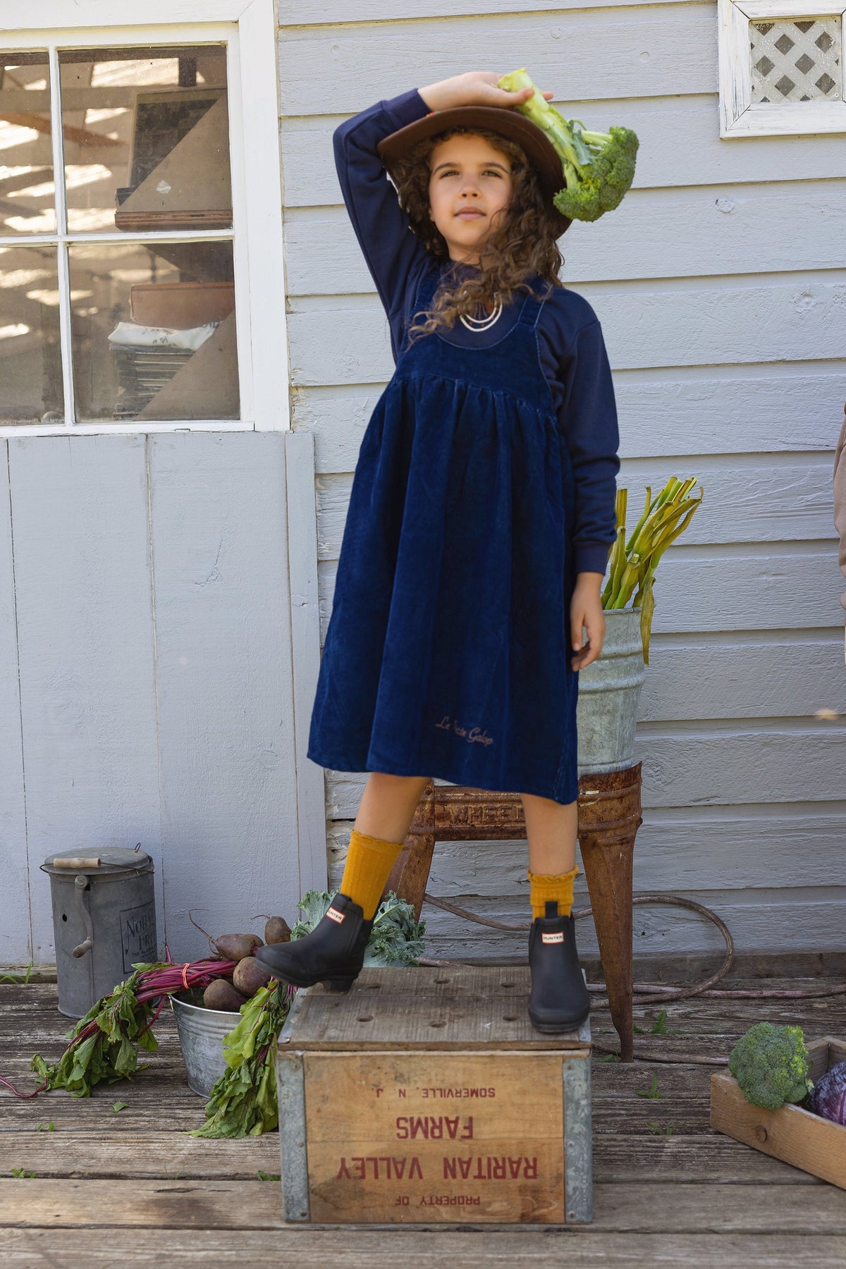 Navy jumper set worn by child: long-sleeve top with horseshoe logo and swing dress