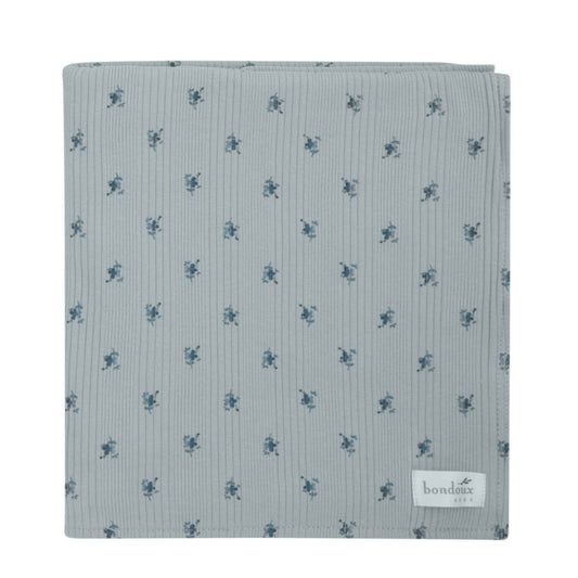 Light blue ribbed soft blanket with small blue floral pattern and stitched brand label