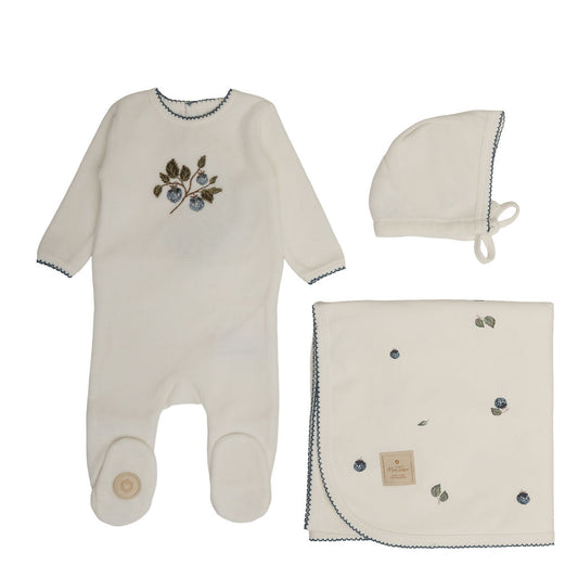 Off-white baby layette set with footed romper, drawstring cap, and printed blanket